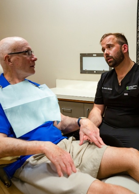 Dentist showing a dental implant model to a patient