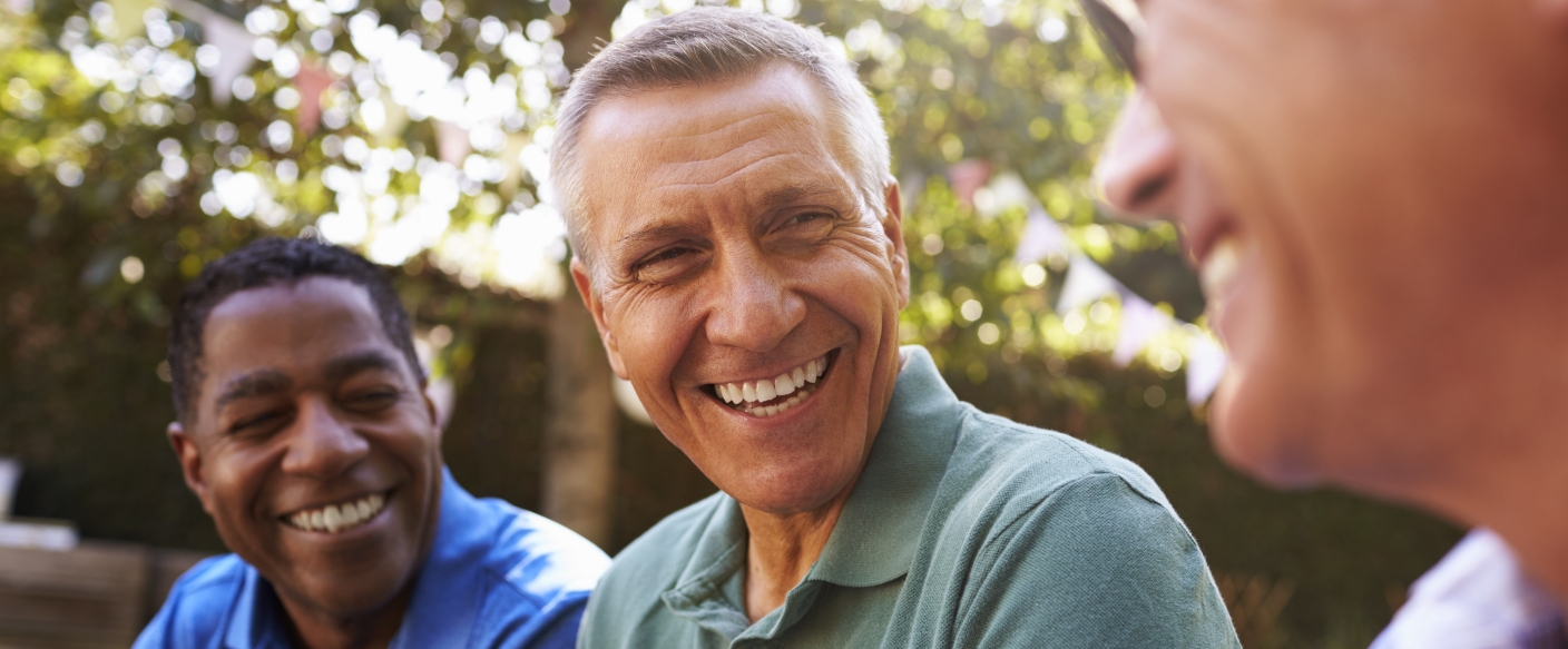 Group of men laughing together outdoors after full mouth reconstruction in Tampa
