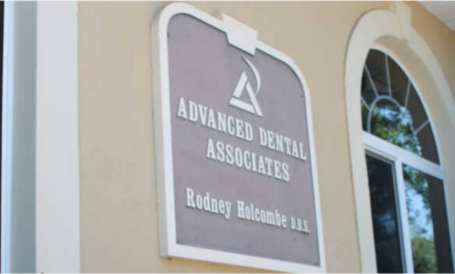 Plaque on wall that reads Advanced Dental Associates Rodney Holcombe D D S