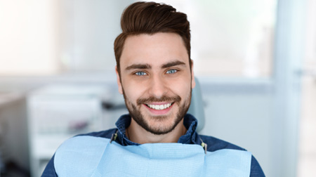 Bearded male patient in treatment chair smiling