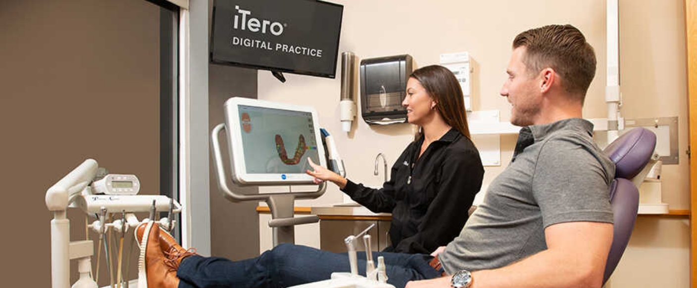 Dentist showing a dental patient digital scans of their teeth