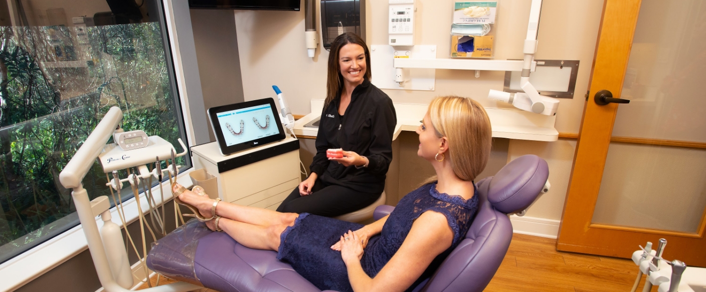 Tampa implant dentist showing a model of a denture to a patient