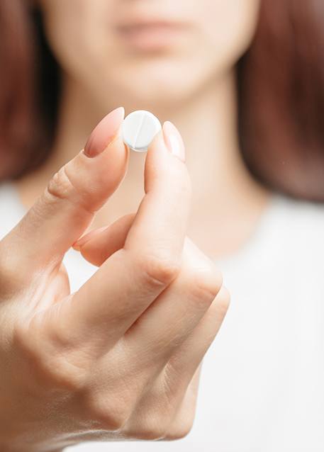 Close-up of woman holding a pill