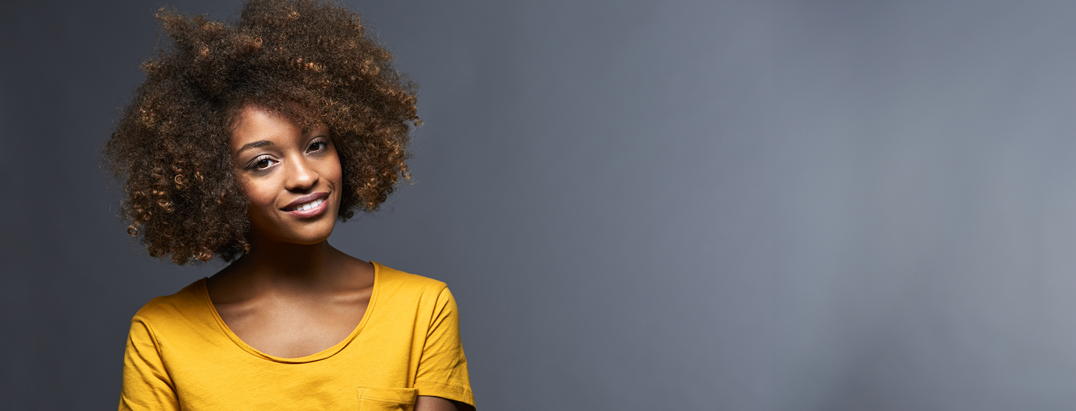Woman in yellow blouse smiling after receiving dental implant services in Tampa